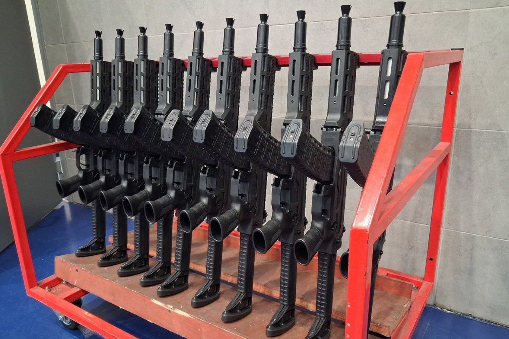 Rows of freshly assembled AM-17 compact assault rifles displayed on a rack at Kalashnikov's facility.