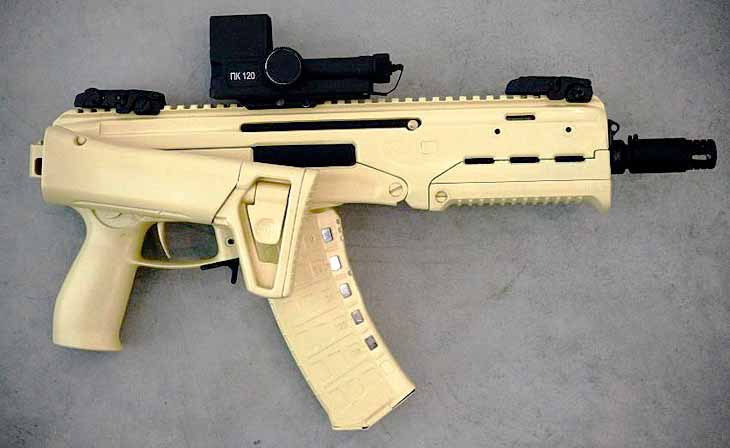 A beige tactical submachine gun with an attached scope, featuring a magazine and a textured grip.